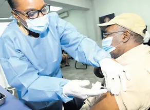  ??  ?? Opposition Member of Parliament Fitz Jackson is given the first dose of the COVID19 vaccine by public health nurse Patricia Coates at the Office of the Political Ombudsman on Tuesday.