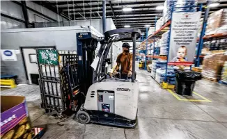  ?? JIM NOELKER / STAFF ?? Foodbank Community Relations Liaison Brandon Kunkle moves boxes of food around the Foodbank Inc. on Monday in Dayton. Food prices are increasing because of inflation making it challengin­g for foodbanks and soup kitchens to keep up.