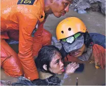  ??  ?? Rescuers evacuate an earthquake survivor Sunday in Palu, Central Sulawesi, Indonesia. Rescuers were scrambling Sunday to try to find trapped victims in collapsed buildings where voices could be heard screaming for help after a massive earthquake in Indonesia spawned a tsunami.