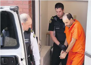  ??  ?? Matthew Vincent Raymond, charged with four counts of first degree murder, is taken from provincial court in Fredericto­n on Monday. — THE CANADIAN PRESS