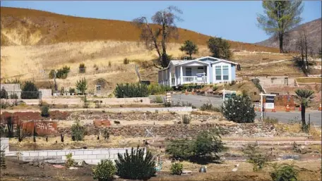  ?? Photograph­s by Gary Coronado Los Angeles Times ?? THE HOME of Richard Lohmann, a 20-year resident of Seminole Springs, sits next to vacant lots of homes destroyed in the Woolsey fire.