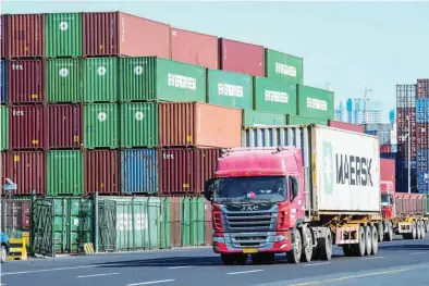  ?? — AFP ?? Containers are stacked at the port in Qingdao, in China’s eastern Shandong province.