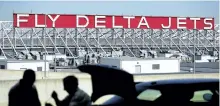  ?? THE ASSOCIATED PRESS FILES ?? A Delta Air Lines sign overlooks the unloading area at Atlanta Internatio­nal Airport, in Atlanta. On Thursday, Delta announced it will order 100 Airbus A321neo jets with a sticker price of $12.7 billion and take an option to buy another 100 jets, a...