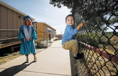  ?? PHOTOS BY LUIS SÁNCHEZ SATURNO/THE NEW MEXICAN ?? Stephanie Solis Mendoza, 18, watches her 2-year-old son, Aiden, play at Capital High School after picking up her cap and gown Thursday. She says she plans to pursue a degree at Santa Fe Community College.