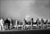  ?? KYLE GRILLOT/GETTY-AFP ?? Police and fire crews watch Thursday as fires burn a hillside in Ojai, Calif., where thousands have been evacuated.