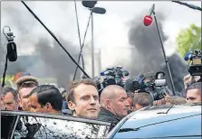  ?? [THIBAULT CAMUS/THE ASSOCIATED PRESS] ?? French presidenti­al candidate Emmanuel Macron, center, leaves the Whirlpool home-appliance factory in Amiens, which he and challenger Marine Le Pen both visited Wednesday.