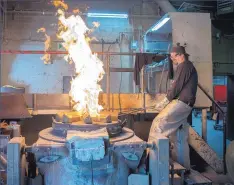  ??  ?? DuWayne Blankley puts bars of bronze into a furnace Wednesday at the now-closed Shidoni Foundry in Tesuque.