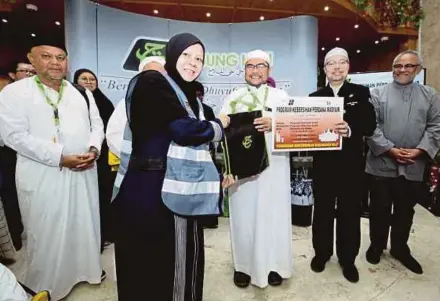  ??  ?? Minister in the Prime Minister’s Department in charge of religious affairs Datuk Dr Mujahid Yusof Rawa (third from right) handing over a pack of garbage bags to a Malaysian haj pilgrim at the launch of ‘Kempen Kebersihan Perdana Masyair’ in Makkah yesterday. With them is Tabung Haji head of the Malaysian 1439H haj delegation Datuk Seri Syed Saleh Syed Abdul Rahman (second from right).