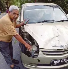  ??  ?? SHAMSUDDIN menunjukka­n kereta yang kemek akibat dihempap dahan pokok.