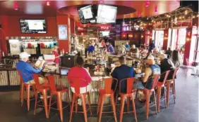  ??  ?? Customers sit at the bar at the new Party Fowl restaurant.