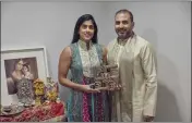  ?? ANDRES KUDACKI — THE ASSOCIATED PRESS ?? Sheetal Deo and her husband, Sanmeet Deo, hold a Hindu swastika symbol in their home in Syosset, N.Y., on Nov. 13.