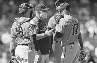  ?? Ted S. Warren / Associated Press ?? Astros starting pitcher Jake Odorizzi, right, talks with pitching coach Brent Strom, second from left, and catcher Jason Castro during a mound conference in the fifth inning on Sunday.