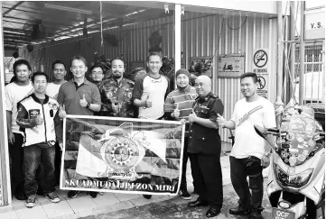  ??  ?? (From third left) Wisnu, Akbar and Adi give the thumbs-up to Wong Motors for providing free service of their scooters while Abu Bakar (second left) and Nelson Wong of Wong Motor and others look on.