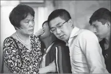  ?? TERRENCE ANTONIO JAMES / CHICAGO TRIBUNE ?? Ye Lifeng ( second from left), mother of murdered Chinese scholar Zhang Yingying, covers her face in grief, as she is supported by a friend Lin Guiping ( left), Zhang’s boyfriend Hou Xiaolin and brother Zhang Zhengyang ( right), during a news conference at the US courthouse in Peoria, Illinois, on July 18, 2019.