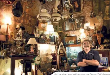  ??  ?? Antique store owner with his treasures. Picture / Getty Images