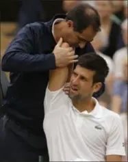  ?? FILE — THE ASSOCIATED PRESS ?? Serbia’s Novak Djokovic as he receives treatment from a trainer during a break in his Men’s Singles Match against Adrian Mannarino of France on day eight at the Wimbledon Tennis Championsh­ips in London. Novak Djokovic will miss the rest of this season...