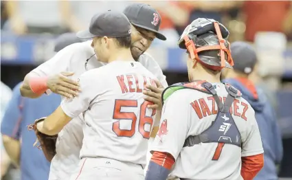  ??  ?? David Ortiz abraza a Joe Kelly luego del triunfo de Boston. Christian Vázquez se une a la celebració­n.