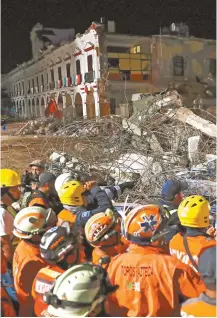 ?? EPA-Yonhap ?? Emergency Services workers inspect the debris of a collapsed building in Juchitan town, Oaxaca, Mexico, Saturday.
