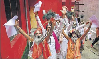  ?? PTI ?? Sadhus chant religious slogans while standing in a queue to get themselves registered for Amarnath Yatra at a base camp, in Jammu on Wednesday.