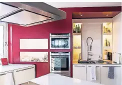  ??  ?? Die offene weiße Küche bekennt nur an einer Wand Farbe. Hier wird auch gegessen – an einem Hochtisch.