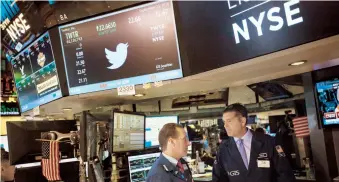  ??  ?? Corredores de bolsa conversan mientras al fondo, un monitor muestra el logo de la red social Twitter en el New York Stock Exchange (NYSE), en Nueva York.