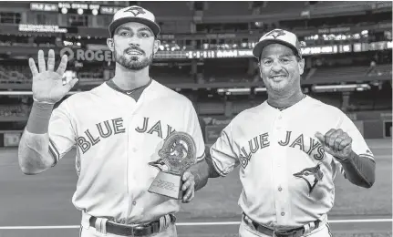  ?? KEVIN SOUSA USA TODAY SPORTS ?? Toronto Blue Jays manager Charlie Montoyo, right, presents the Roberto Clemente Award to Randal Grichuk prior to an MLB game against the Baltimore Orioles on Monday. •