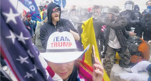  ?? JOHN MINCHILLO/AP ?? Supporters of President Donald Trump try to break through a police barrier on Wednesday at the Capitol in Washington. A Capitol Police officer was among the five people killed.