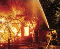  ?? PHOTO/NOAH BERGER ?? A firefighte­r sprays water on a burning home as the Kincade Fire burns through the Jimtown community of unincorpor­ated Sonoma County, on Thursday. AP