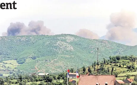  ?? — AFP file photos ?? Smoke rises from Kosovo behind the hills overlookin­g the Morina border checkpoint May 12, 1999 after a Nato airstrike on Serb forces in Yugoslavia close to the border with Albania.