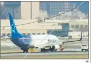  ?? AP ?? An Air Transat plane is towed Saturday along the runway at Newark Liberty Internatio­nal Airport in New Jersey in this image taken from a TV news report. The airport temporaril­y closed both of its runways after the plane made an emergency landing.