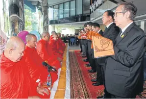  ?? SOMCHAI POOMLARD ?? LEFT Suthikiati Chirathiva­t, chairman of the Bangkok Post board and chairman of the executive committee, leads participan­ts in presenting necessitie­s to the monks.