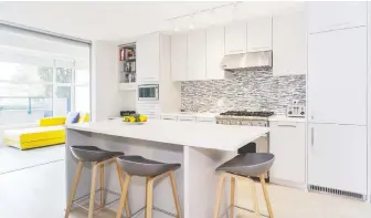  ??  ?? Natural light permeates the custom kitchen in this one-bedroom unit at 209 - 4355 West 10th Ave. in Vancouver.