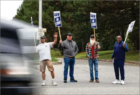  ?? EMILY ELCONIN/ BLOOMBERG ?? United Auto Workers members and supporters gather on a picket line outside the General Motors Flint Processing Center in Swartz Creek, Mich., last week. They want more than just an increase in hourly pay for workers. They want a return to guaranteed pensions.