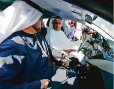  ??  ?? Mattar Al Tayer, director general and chairman of the board of executive directors of RTA, is briefed by Adel Shakeri, RTA’s director of transporta­tion system, at the launch of new car rental service at the Dubai Water Canal yesterday. Right: Cars...