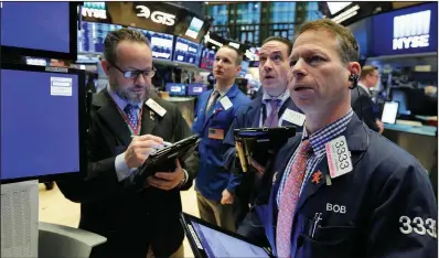  ?? AP/RICHARD DREW ?? Robert Charmak (right) is joined Friday by fellow traders at a post on the floor of the New York Stock Exchange. Concerns about President Donald Trump’s plan to impose tariffs on steel and aluminum imports caused fluctuatio­ns in the S&P 500 on Friday...