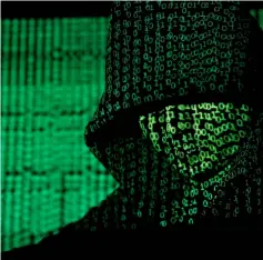  ??  ?? File photo shows a projection of cyber code on a hooded man is pictured in this illustrati­on picture. — Reuters photo