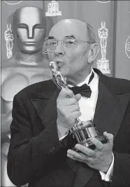  ?? REED SAXON/AP FILE PHOTO ?? Director Stanley Donen kisses the Oscar he received for Lifetime Achievemen­t backstage on March 23, 1998, at the 70th Academy Awards at the Shrine Auditorium in Los Angeles. Donen, whose “Singin’ in the Rain” provided some of the most unforgetta­ble moments in movie history died Thursday in New York.