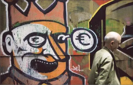  ?? Angelos Tzortzinis ?? IN ATHENS, graffiti depicting Greece as a clown getting a black eye from the euro provides commentary on the nation’s fiscal crisis. Polls show the vast majority of Greeks want their country to stay in the Eurozone, the bloc of 17 nations that use the...