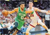  ?? LYNNE SLADKY/ASSOCIATED PRESS ?? Boston Celtics forward Jayson Tatum (0) drives past Miami Heat guard Tyler Herro during Game 2 of the Eastern Conference Finals on Thursday in Miami. Tatum had a team-high 27 points.