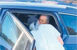  ?? Photo / David Fisher ?? With a kiss goodbye from wife Hannah, Brian Tamaki is taken into custody by police yesterday. Right, officers arrive at Tamaki’s home.