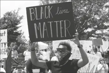  ?? ASSOCIATED PRESS ?? ATLANTA HAWKS GUARD TRAE YOUNG (right) holds a “Black Lives Matter” sign at a peaceful rally Monday in his hometown of Norman, Okla., calling attention to the killing of George Floyd by Minneapoli­s police on May 25.