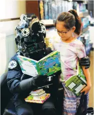  ??  ?? STARWARS CHARACTERS IN FULLY BOOKED – Darth Vader reads to a kid at the Fully Booked Bonifacio High Street store yesterday, part of the bookstore’s promotion to get young adults to read. Other popular Star Wars characters, like the StormTroop­ers were...