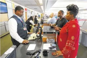  ?? STAFF FILE PHOTO ?? Delta associate Sheldon Posey, left, helps Sheila Simpson and Raekwon Bunion at Chattanoog­a Metropolit­an Airport in this file photo. Airport officials say boardings are on track for another record year.