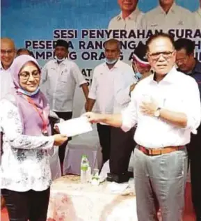  ?? (Foto Mohd Rafi Mamat/bh) ?? Wan Rosdy menyampaik­an surat tawaran Rancangan Tanah Kelompok RTK Khas kepada Nashita Dewi di Kampung Orang Asli Gumum, Chini, semalam.