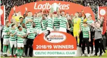  ?? Files/Reuters ?? Celtic’s Scott Brown lifts the trophy as he celebrates winning the Premiershi­p with teammates in this May 19, 2019 file photo.