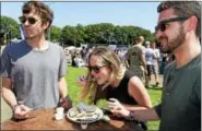  ?? (PETER HVIZDAK / HEARST CONNECTICU­T MEDIA) ?? Milford, Connecticu­t: Saturday. Taylor Johnston of New York City, left, Katie Suffredini of West Haven, center, and Jared Hawly of New Haven, right, eat Oysters at the Milford Oyster Festival in Milford.