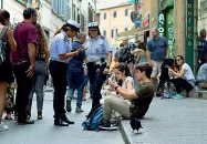  ??  ?? Turisti in via de’ Neri mentre consumano sul marciapied­e i propri panini A sinistra l’assessore Gianassi nel proprio studio