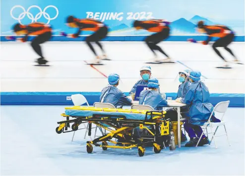  ?? TYRONE SIU / REUTERS ?? Medical staff chat during a speedskati­ng training session for the 2022 Winter Olympics in Beijing on Friday.