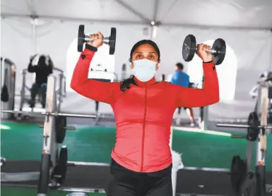  ?? Photos by Gabrielle Lurie / The Chronicle ?? Kat Velasquez exercises in the outdoor tent area at 24 Hour Fitness in Walnut Creek.