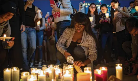  ?? DREW ANGERER / GETTY IMAGES ?? Mourners light candles Monday night on the corner of Sahara Avenue and Las Vegas Boulevard for the victims of Sunday night’s shooting at the Route 91 Harvest Festival of country music in Las Vegas. Stephen Paddock, 64, killed himself after firing into...